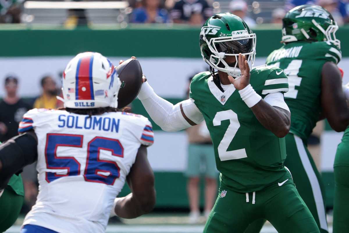 Jets quarterback in green uniform set to throw ball