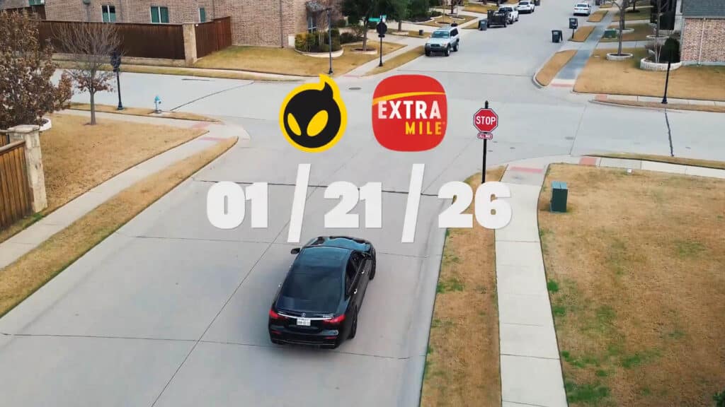 Image of Dignitas and ExtraMile logos underneath white text. A black car driving towards a stop sign is in the background